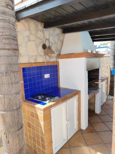 a kitchen with a stove and a blue tile counter at Casa Pozuelo in Taramay