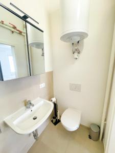 bagno con lavandino, servizi igienici e specchio di StayHere Central City Studio 4 - contactless Self-Check-IN a Graz