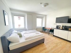 1 dormitorio con 1 cama, cocina y mesa en StayHere Central City Studio 4 - contactless Self-Check-IN, en Graz