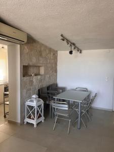 a dining room with a table and chairs and a stone wall at Front Sea Villa Polichrono in Kriopigi