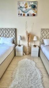 a bedroom with two beds and two tables with lamps at Wonderful two bed room with full marina view in Dubai