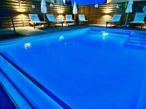 una piscina con luces azules en un edificio en Villa Trousas Kassiopi with private pool, en Kassiopi