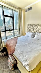 a bedroom with a large bed with a large window at Wonderful two bed room with full marina view in Dubai
