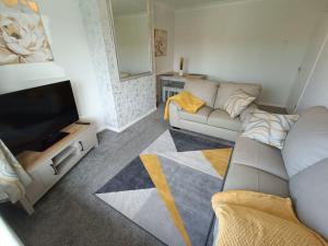 a living room with a couch and a flat screen tv at Alton Towers/Foxfield & Oak Barns/Peak District in Wetleyrocks