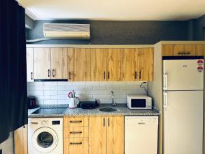 een keuken met houten kasten en een witte koelkast bij Disa Hotel & Apart in Istanbul