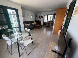a living room with a glass table and chairs at Casa La Estrella Playa Blanca Lanzarote in Playa Blanca