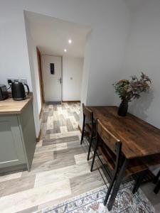 a dining room with a wooden table and a kitchen at Small home in Llanfairpwll in Llanfairpwllgwyngyll +5 photos