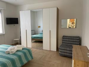 a bedroom with a mirror and a bed and a chair at LA CASETTA AL MARE in Savona