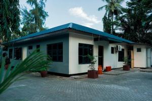 une petite maison avec un toit bleu dans l'établissement GE-Homes, à Dar es Salaam