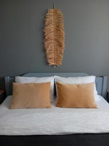 um quarto com uma cama com duas almofadas em Zvejnieku apartamenti em Roja