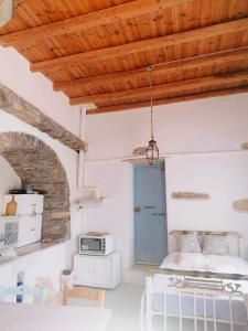 una camera da letto con pareti bianche e soffitto in legno di Naxos Mountain Retreat - Tiny House Build on Rock a Kóronos