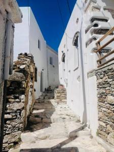 Une allée dans un village avec des bâtiments blancs dans l'établissement Naxos Mountain Retreat - Tiny House Build on Rock, à Kóronos