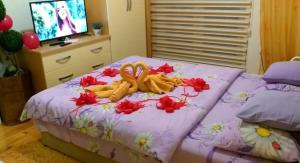 Un dormitorio con una cama con flores. en Apartmani GS ***** Zavidovici, en Zavidovići