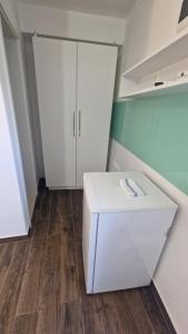 een lege kamer met een witte koelkast en kasten bij Apartments Ante in Hvar