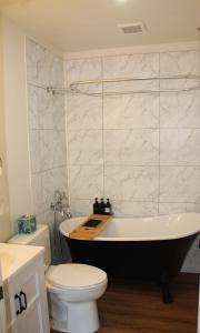 a bathroom with a black and white tub and a toilet at Quiet Mind Lodge, Spa & Retreat Sequoias in Kernville