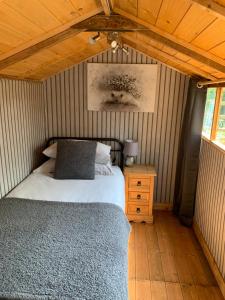 1 dormitorio con cama y techo de madera en Hedgehog Lodge en Colwall