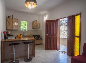 a kitchen with a counter and stools in a room at Liza's Place in Metókhion