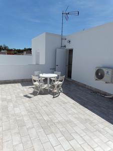 - une terrasse avec une table et des chaises dans un bâtiment dans l'établissement Apartamento Vitelio, à Carmona