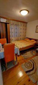 1 dormitorio con 1 cama, mesa y sillas en Apartmani GS ***** Zavidovici, en Zavidovići