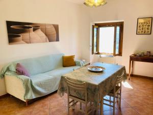a living room with a blue couch and a table at Casa nella natura a Bobbio in Bobbio