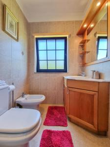 uma casa de banho com um WC branco e um lavatório. em Quarto em Viana do Castelo em Viana do Castelo