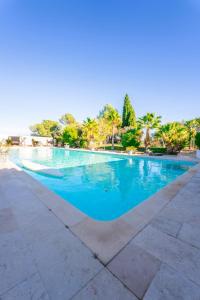 una piscina con agua azul y palmeras en DOMAINE DE LA SOURCO - Villa, Maisons & Chalet, Magnifique Havre De Paix En Provence en Trans-en-Provence
