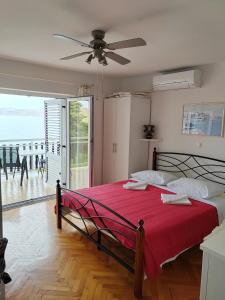 a bedroom with a large red bed with a view of the ocean at Plaza 2 in Sveti Juraj