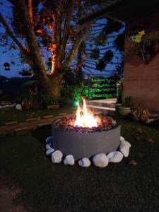 eine Feuerstelle in einem Garten mit Steinen drum herum in der Unterkunft Chalé Alecrin, lançamento em conforto e estilo! in Campos do Jordão