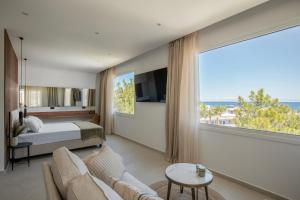 sypialnia z łóżkiem i dużym oknem w obiekcie Theros Luxury Apartment w mieście Archangelos