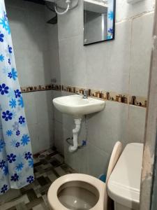 La petite salle de bains est pourvue d'un lavabo et de toilettes. dans l'établissement CHAVIN inn with kitchen compartida Lima, à Lima