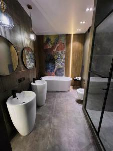 un bagno con due lavandini, una vasca e un tubermott di Royal Lux апартаменты в ЖК ZAMAN a Atyraū
