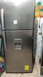 - un réfrigérateur en acier inoxydable dans une cuisine avec des autocollants dans l'établissement CHAVIN inn with kitchen compartida Lima, à Lima