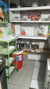a kitchen with white shelves and pots and pans at CHAVIN inn with kitchen compartida Lima in Lima