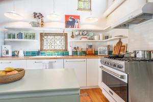 a kitchen with white cabinets and a stove top oven at Heart of Santa Fe - Adorable Hideaway - King and Queen - Walk to Everything - Fireplace - AC in Santa Fe