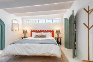 a bedroom with a large bed with an orange headboard at Heart of Santa Fe - Adorable Hideaway - King and Queen - Walk to Everything - Fireplace - AC in Santa Fe +9 photos