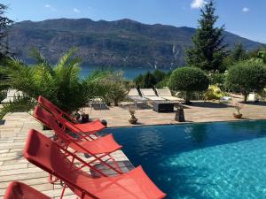 a group of red chairs sitting next to a swimming pool at Les Suites du Lac in Aix-les-Bains