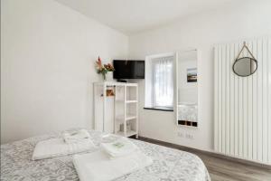 a white bedroom with a bed with towels on it at La Casa di Luna in Riomaggiore