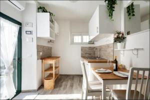 a kitchen with white cabinets and a table and chairs at La Casa di Luna in Riomaggiore