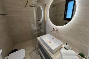 y baño con lavabo blanco y espejo. en Queen of Zakynthos Luxury Villas en Amoudi