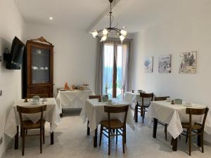 a restaurant with white tables and chairs and a chandelier at Agriturismo "Casale Perla" in Norcia