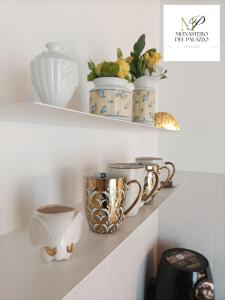a shelf with cups and vases on it at Monastero Del Palazzo Casa Vacanze in Spoleto +23 photos