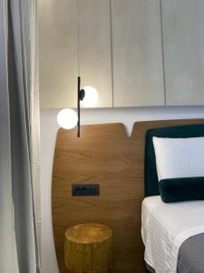 a bedroom with a bed and a wooden headboard at Tramonto Maisonettes & Suites in Parga