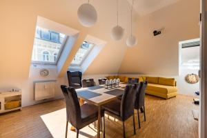 een eetkamer met een tafel, stoelen en een bank bij TAMLiving Graz Center 2 Schlafzimmer Comfort Air conditioning WIFI XBOX in Graz