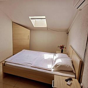 een bed in een kleine kamer met een plafond bij Authentic 2018 in Šid