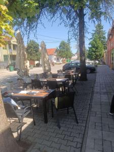 een rij tafels en stoelen met parasols op straat bij Authentic 2018 in Šid