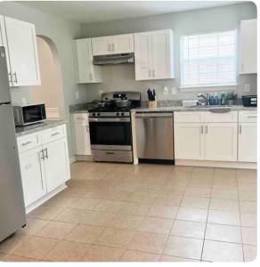 a kitchen with white cabinets and a stove at King Suite - Private Bath - Hot Tub Room 1 in Atlanta