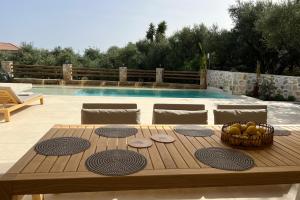 a wooden table with a basket of fruit on it at Queen of Zakynthos Luxury Villas in Amoudi