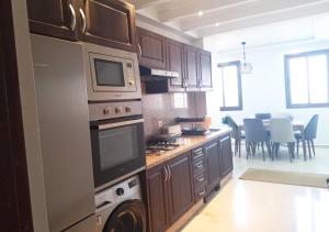 una cucina con lavatrice e forno e una sala da pranzo di Prestigia EN Naim J-5 a Marrakech