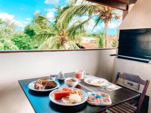 a table with plates of food on a balcony at Vai dá Certo in Jericoacoara