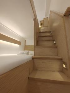 Una escalera que conduce a un dormitorio con cama en VG Pension & Residences en Adlawon